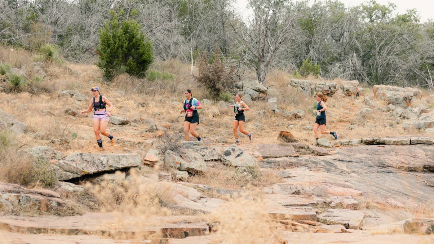 Four runners on granite and rocky Hill Country trail at the Austin Rattler