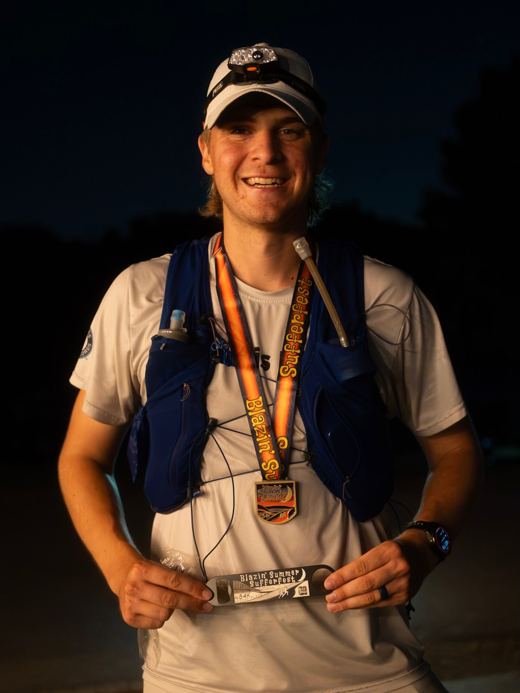 Runner with a finisher medal after the Blazin' Summer Sufferfest 54K ultramarathon