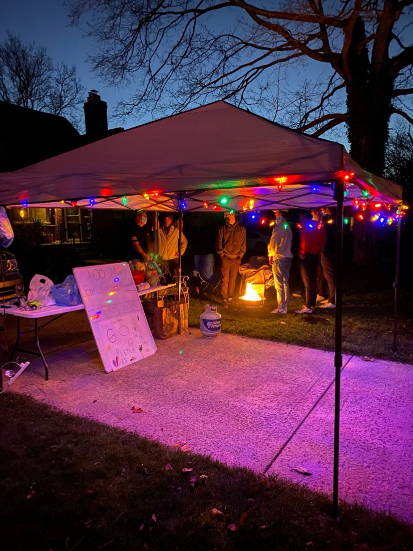 Pop-up tent with Christmas lights, a fire pit and a 100 Miles for Cancer Research sign that served as Pierce Showe's aid station during his first 100-mile run