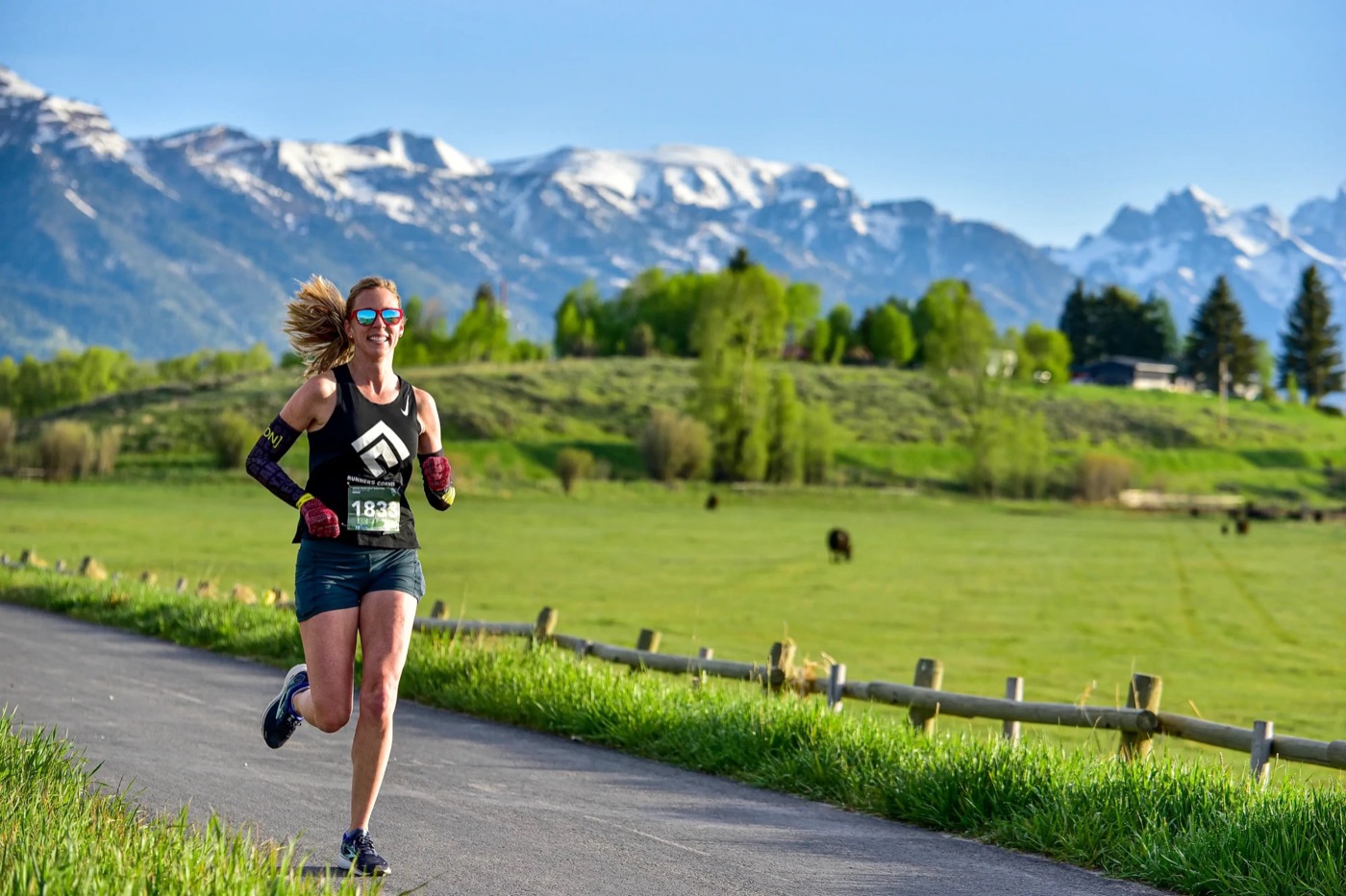 A runner on the Grand Teton Half Marathon course with the Tetons behind her