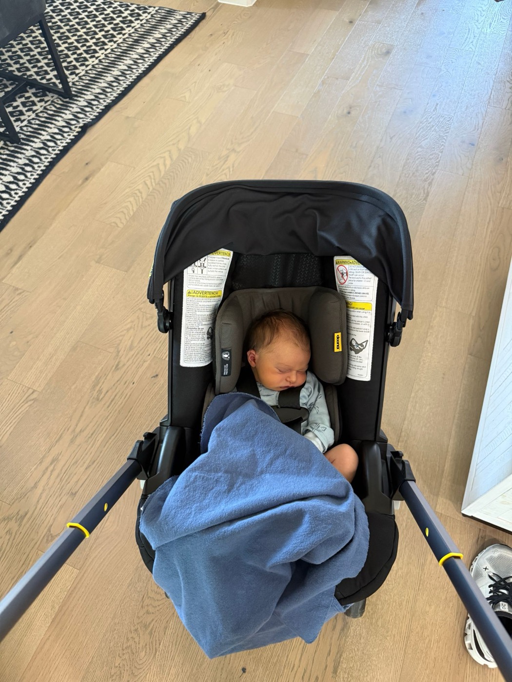 Newborn John asleep under a blue blanket in his car seat stroller