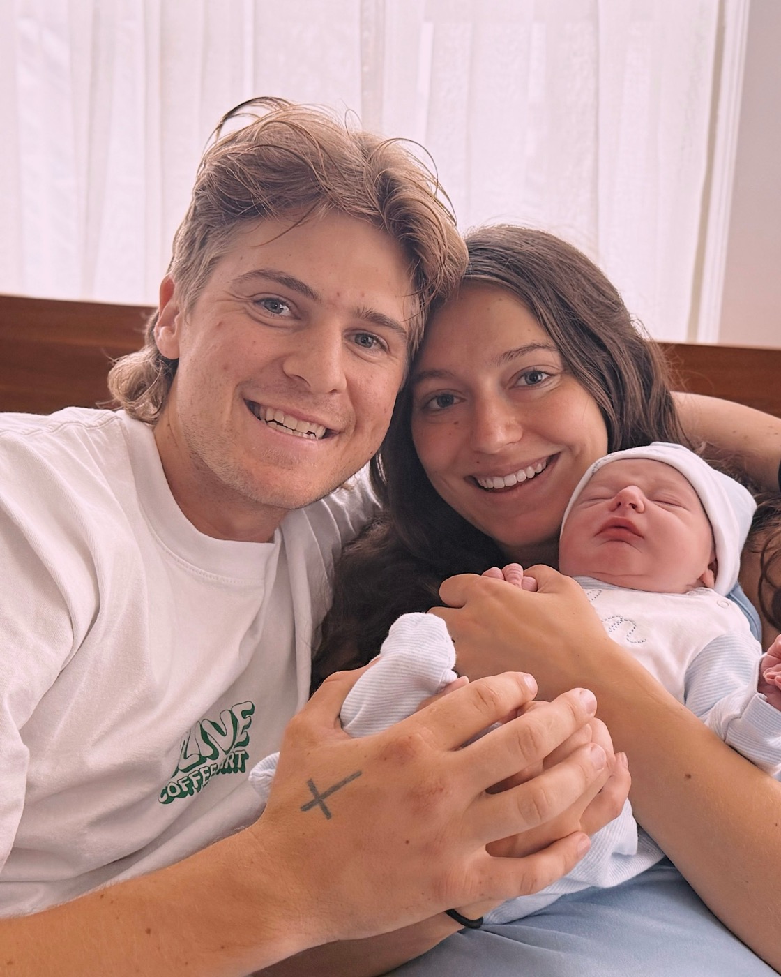 Pierce Showe and his wife Ashley smiling with their newborn son John in the hospital