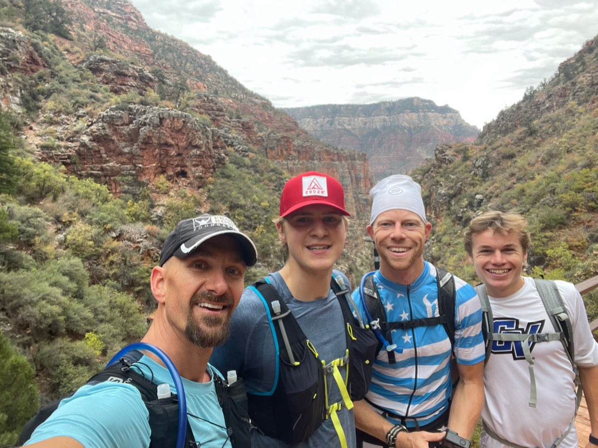 Pierce Showe and three friends smiling inside the Grand Canyon during their Rim to Rim to Rim run