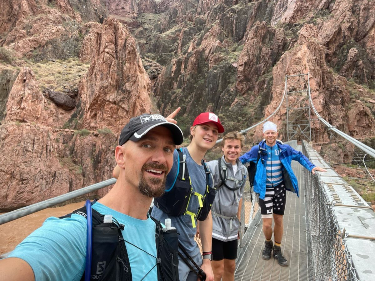 Pierce Showe's group on a suspension bridge over the Colorado River at the bottom of the Grand Canyon during a Rim to Rim to Rim run