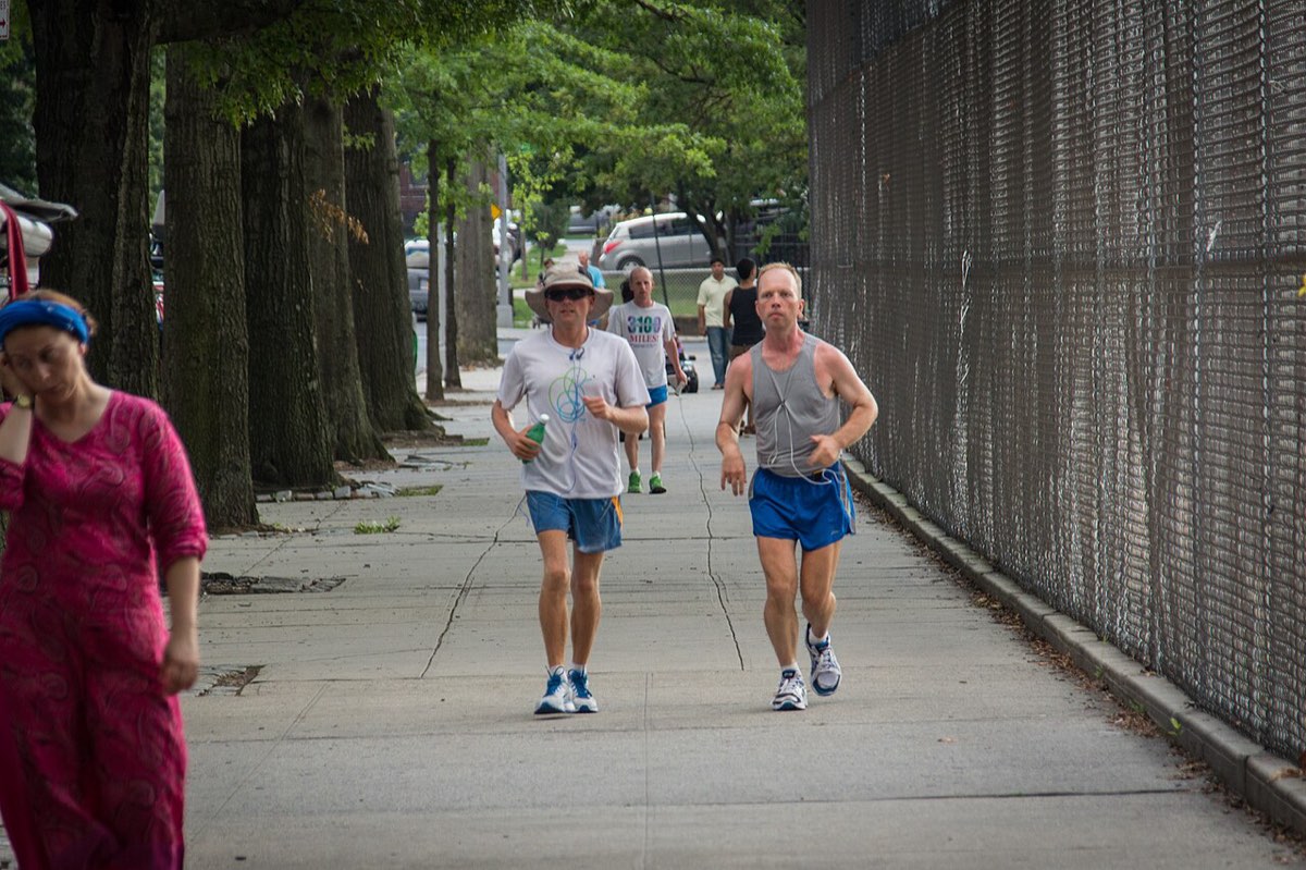Runners on the sidewalk loop of the Self-Transcendence 3100 Mile Race in Queens, New York
